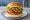 Vejetaryen Burger: an illustration of lettuce, tomato and onion on burger bun.