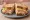 Vermonter Sandwich: an illustration of turkey, ham, cheddar cheese, apple and more on sourdough.