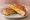 Welsh Rarebit Sandwich: an illustration of cheddar cheese, mustard and butter on white bread.