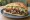 Yaprak Döner: an illustration of beef, lamb, onion, tomato and more on bread.