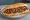 Yarma Kokoreç: an illustration of lamb, oregano, cumin, tomato and more on bread.