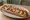 Zapiekanka: an illustration of cheese, onion, ketchup, garlic sauce and more.