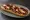 Zapiekanka Góralska: an illustration of pork, mushroom, onion and cranberry sauce.