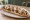 Zapiekanka Gourmet: an illustration of pork, mushroom, cheese, onion and more.