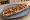 Zapiekanka z Kiełbasą: an illustration of kielbasa, mushroom, cheese, onion and more.