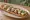 Zapiekanka z Mozzarellą: an illustration of mozzarella, mushroom, tomato, onion and more.