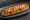 Zapiekanka z Warzywami: an illustration of mushroom, cheese, pepper, onion and more.